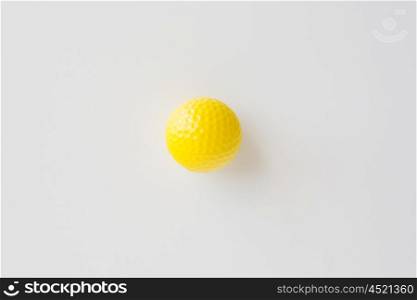 sport, fitness, game, sports equipment and objects concept - close up of yellow golf ball over white background from top