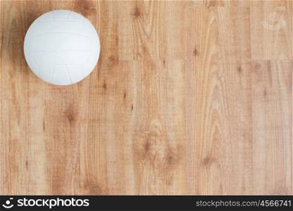 sport, fitness, game, sports equipment and objects concept - close up of volleyball ball on wooden floor from top