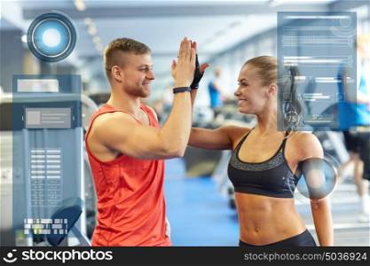 sport, fitness, gesture and people concept - smiling man and woman doing high five in gym over virtual charts. smiling man and woman doing high five in gym