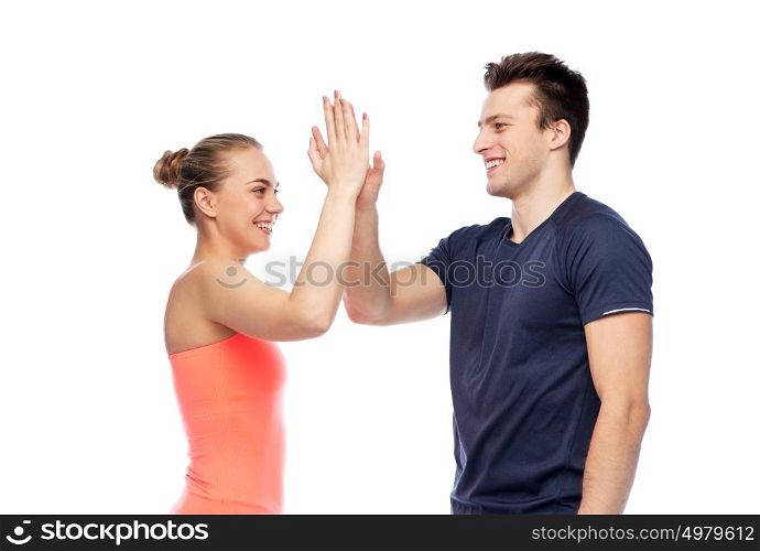 sport, fitness, gesture, lifestyle and people concept - smiling man and woman making high give. happy sportive man and woman making high five