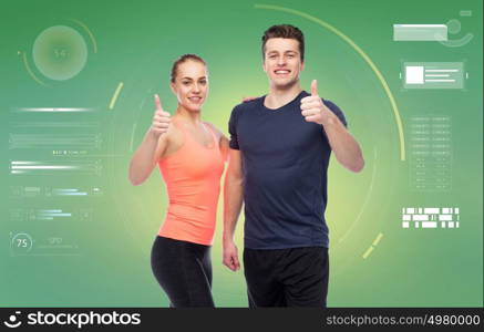 sport, fitness, gesture, technology and people concept - happy sportive man and woman showing thumbs up over green background. happy sportive man and woman showing thumbs up