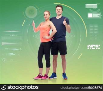 sport, fitness, gesture, technology and people concept - happy sportive man and woman showing thumbs up. happy sportive man and woman showing thumbs up