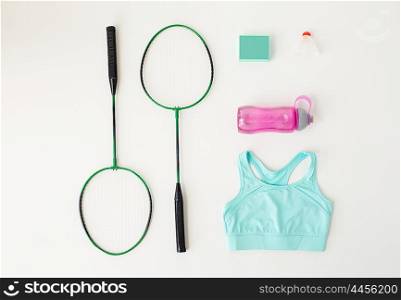 sport, fitness, healthy lifestyle and objects concept - close up of badminton rackets with speaker and sports stuff over white background