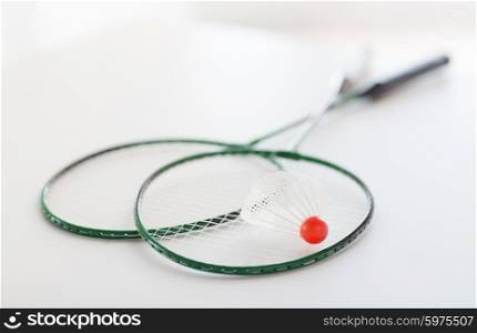 sport, fitness, healthy lifestyle and objects concept - close up of badminton rackets with shuttlecock