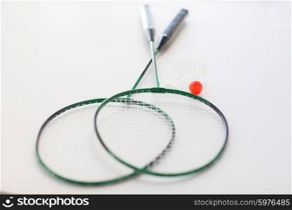 sport, fitness, healthy lifestyle and objects concept - close up of badminton rackets with shuttlecock