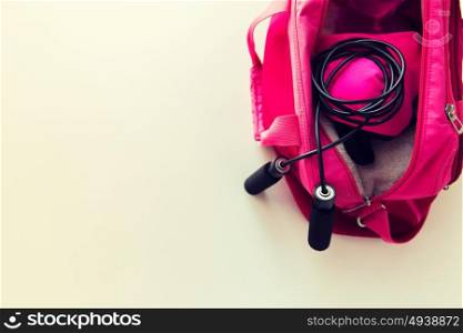 sport, fitness, healthy lifestyle and objects concept - close up of female sports stuff in bag and skipping rope. close up of female sports stuff in bag