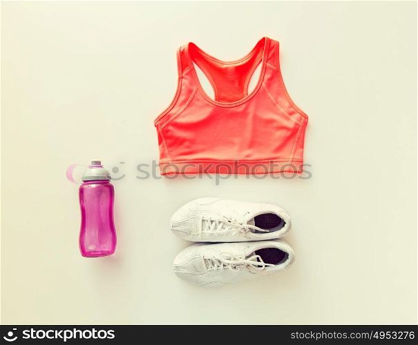 sport, fitness, healthy lifestyle and objects concept - close up of female sports clothing and bottle set. close up of female sports clothing and bottle set