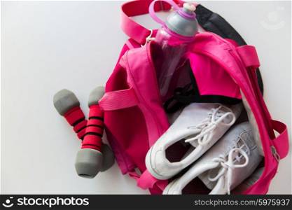 sport, fitness, healthy lifestyle and objects concept - close up of female sports stuff in backpack and dumbbells