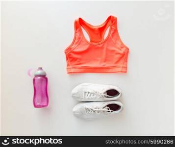 sport, fitness, healthy lifestyle and objects concept - close up of female sports clothing and bottle set