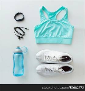 sport, fitness, healthy lifestyle and objects concept - close up of female sports clothing, heart-rate watch, earphones and bottle set