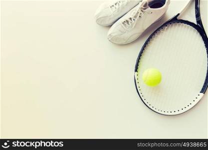 sport, fitness, healthy lifestyle and objects concept - close up of tennis racket with ball and sneakers. close up of tennis racket with ball and sneakers