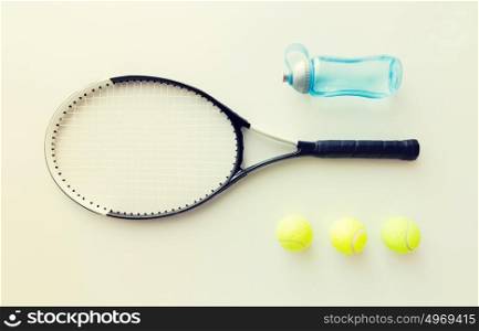 sport, fitness, healthy lifestyle and objects concept - close up of tennis racket with balls and bottle. close up of tennis racket with balls and bottle