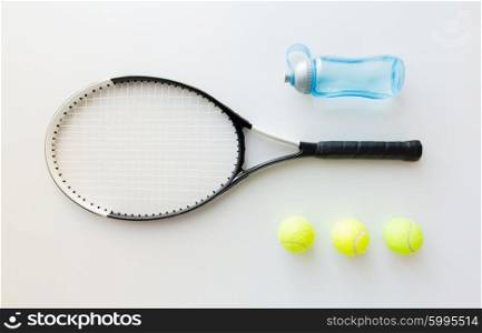 sport, fitness, healthy lifestyle and objects concept - close up of tennis racket with balls and bottle