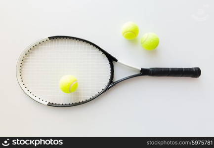 sport, fitness, healthy lifestyle and objects concept - close up of tennis racket with balls