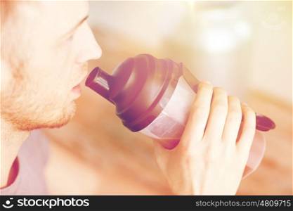 sport, fitness, healthy lifestyle and people concept - close up of man with jar and bottle drinking protein shake