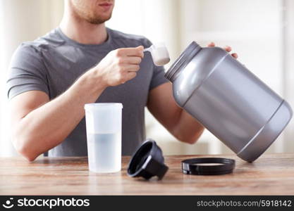 sport, fitness, healthy lifestyle and people concept - close up of man with jar and bottle preparing protein shake