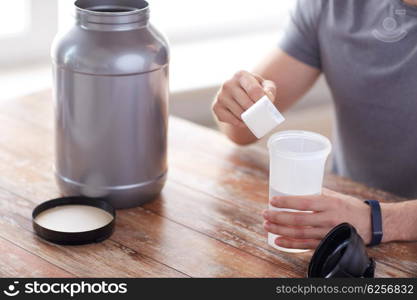 sport, fitness, healthy lifestyle and people concept - close up of man in fitness bracelet with jar and bottle preparing protein shake