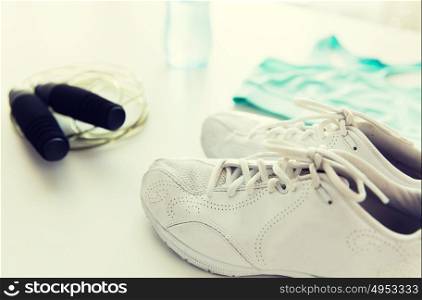 sport, fitness, healthy lifestyle, cardio training and objects concept - close up of female sports clothing, skipping rope and bottle set. close up of sportswear, skipping rope and bottle