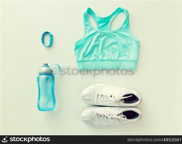 sport, fitness, healthy lifestyle, cardio training and objects concept - close up of female sports clothing, heart-rate watch and bottle set. close up of sportswear, bracelet and bottle