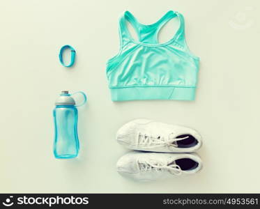 sport, fitness, healthy lifestyle, cardio training and objects concept - close up of female sports clothing, heart-rate watch and bottle set. close up of sportswear, bracelet and bottle