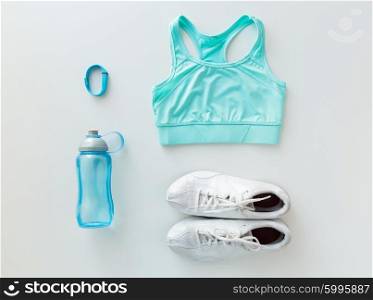 sport, fitness, healthy lifestyle, cardio training and objects concept - close up of female sports clothing, heart-rate watch and bottle set