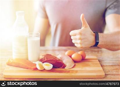 sport, fitness, healthy lifestyle, diet and people concept - close up of man with food rich in protein showing thumbs up