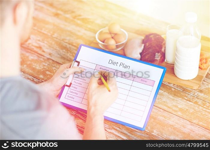 sport, fitness, healthy lifestyle, diet and people concept - close up of male hands with food rich in protein on cutting board on table