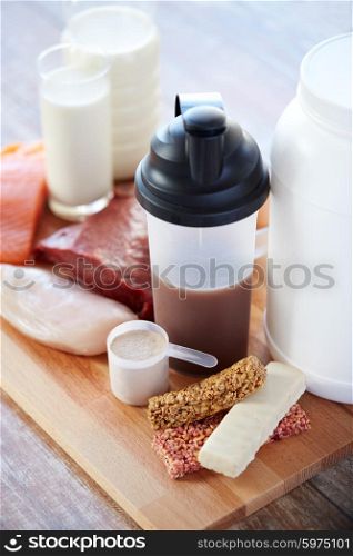 sport, fitness, healthy lifestyle, diet and people concept - close up of natural protein food and additive on wooden table