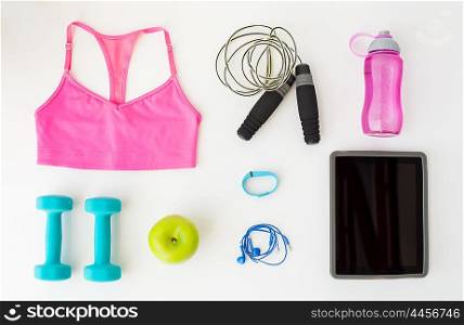 sport, fitness, healthy lifestyle, technology and objects concept - close up of tablet pc computer with sports stuff over white background