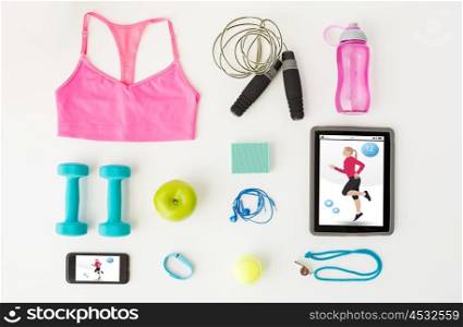 sport, fitness, healthy lifestyle, technology and objects concept - close up of tablet pc computer with smartphone and sports stuff over white background