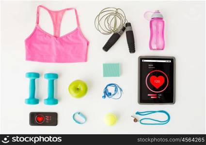 sport, fitness, healthy lifestyle, technology and objects concept - close up of tablet pc computer and smartphone with heart rate on screens and sports stuff over white background