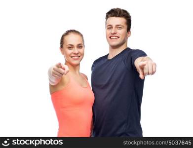 sport, fitness, lifestyle and people concept - happy sportive man and woman pointing finger on you. happy sportive man and woman pointing finger