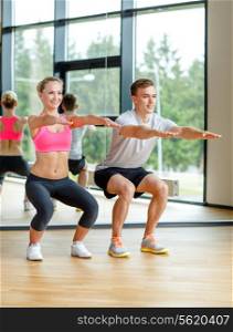sport, fitness, lifestyle and people concept - smiling man and woman exercising in gym