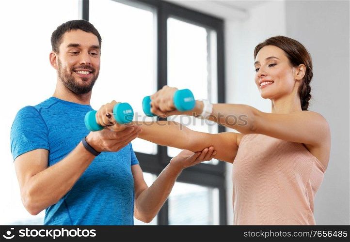 sport, fitness, lifestyle and people concept - smiling man and woman exercising with dumbbells at home. happy couple exercising at home