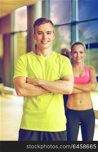 sport, fitness, lifestyle and people concept - smiling man and woman in gym. smiling man and woman in gym