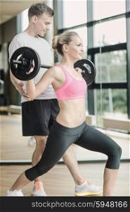 sport, fitness, lifestyle and people concept - smiling man and woman with barbell exercising in gym