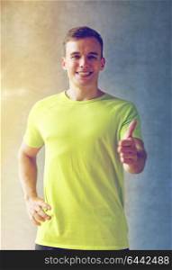 sport, fitness, lifestyle and people concept - smiling man showing thumbs up in gym. smiling man in gym