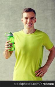 sport, fitness, lifestyle and people concept - smiling man with bottle of water in gym