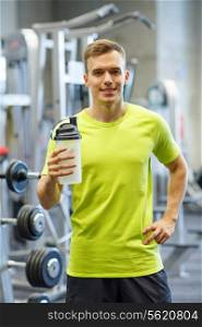 sport, fitness, lifestyle and people concept - smiling man with protein shake bottle in gym