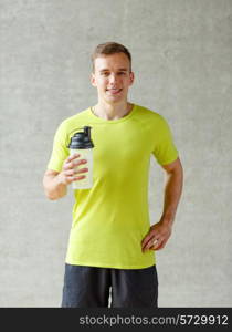 sport, fitness, lifestyle and people concept - smiling man with protein shake bottle in gym