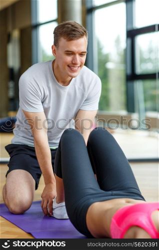 sport, fitness, lifestyle and people concept - smiling woman with male personal trainer exercising in gym