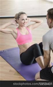 sport, fitness, lifestyle and people concept - smiling woman with male personal trainer exercising in gym