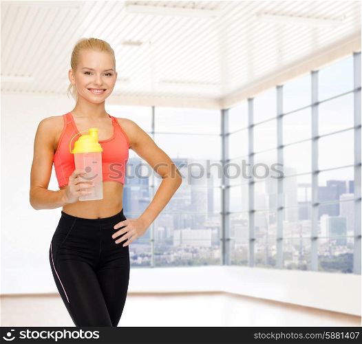 sport, fitness, lifestyle and people concept - smiling young woman with protein shake bottle over gym or home background