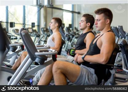 sport, fitness, lifestyle, technology and people concept - men working out on exercise bike in gym