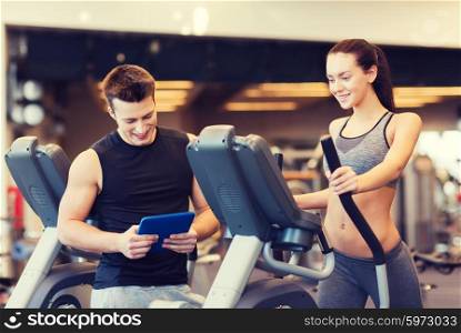 sport, fitness, lifestyle, technology and people concept - woman with trainer exercising on stepper in gym