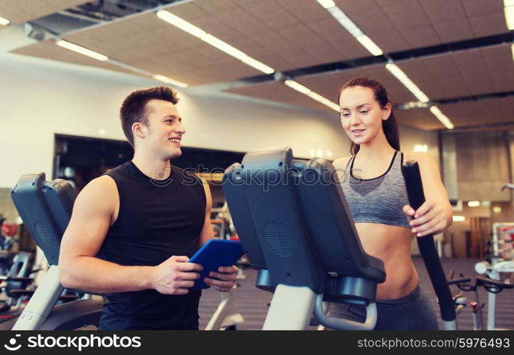 sport, fitness, lifestyle, technology and people concept - woman with trainer exercising on stepper in gym