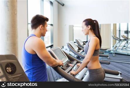 sport, fitness, lifestyle, technology and people concept - woman with trainer working out on treadmill in gym