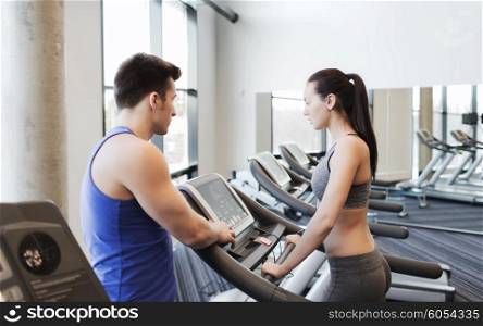 sport, fitness, lifestyle, technology and people concept - woman with trainer working out on treadmill in gym