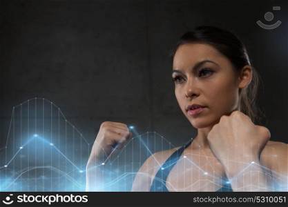sport, fitness, martial arts and people concept - woman holding fists and fighting in gym. woman holding fists and fighting in gym