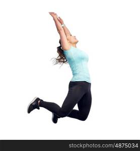 sport, fitness, motion and people concept - happy smiling young woman jumping in air or dancing over white background